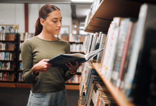 Person reading a book in a cozy library setting